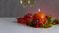 Greeting card template made of golden and green tinsel with red christmas balls, red ribbon, orange candle and two glasses of cham Royalty Free Stock Photo