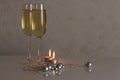 Greeting card template made of two glasses of champagne with two candles, silver christmas balls and silver string of beads with c