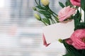 A greeting card template with a place for text, a photo of a blank card in a bouquet of lisianthus flowers