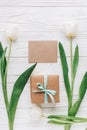Greeting card template with stylish present box and tulips on w Royalty Free Stock Photo