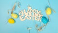 greeting card with text happy easter. multicolored easter eggs on blue background