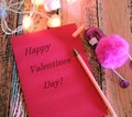 Greeting card with text Happy Valentines Day and Pen with toy pink flamingo . In dark settings. Concept of love and romance