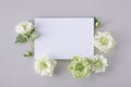 Greeting card trendy mockup or invitation template with empty blank paper sheet decorated fresh flowers flat lay Royalty Free Stock Photo