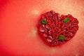 Greeting card with Valentine`s Day. confectionery Raspberry tart with mint in the form of a heart, lies on a red background Royalty Free Stock Photo