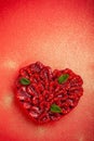 Greeting card with Valentine`s Day. confectionery Raspberry tart with mint in the form of a heart, lies on a red background Royalty Free Stock Photo