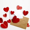 Greeting card for Valentine`s Day. Envelopes on a white background and red plastic hearts Royalty Free Stock Photo