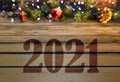 Greeting card 2021 on wooden table and christmas oranment in lights background Royalty Free Stock Photo