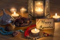 Greeting card writing Happy Ramadan with dates, rosary, candles on wooden table Royalty Free Stock Photo