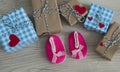 Greeting children card. Pink boots and gift boxeswith red heart. Top view