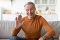 Greeting Concept. Mature man waving hand at camera Royalty Free Stock Photo