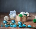 Greeting easter card with eggs in a basket, decorative wicker balls and a twig with blue eggs
