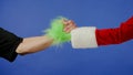 Greeting gestures of man and Grinchs hairy green hand on isolated blue background. Gift kidnapper cosplay Royalty Free Stock Photo