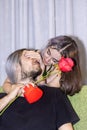 Smiling woman covering her man eyes and giving her bunch of red roses, making surprise to beautiful Royalty Free Stock Photo