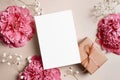 Greeting or invitation card mockup with pink peony flowers and gift box on paper background Royalty Free Stock Photo