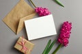 Greeting or invitation card stationary mockup with envelope, gift box and fresh hyacinth flowers on grey Royalty Free Stock Photo
