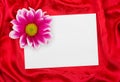 Greeting paper card and flower on red cloth