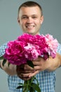 Greetings. Close up of smiling man giving bouquet of flowers. Royalty Free Stock Photo