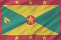 Grenada flag depicted on folded wavy fabric of old cloth