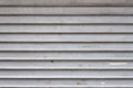 Grey aluminum automatic garage shutter closeup, steel striped sliding door, texture and pattern, old and weathered surface, dirty Royalty Free Stock Photo