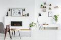 Grey armchair next to table in scandi living room interior with