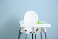 Baby nibbler on high chair against grey background