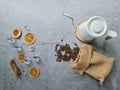 Grey background decorated with dried orange slices, cinnamon sticks, cubic ices, kettle on pine wood chip and coffee bean Royalty Free Stock Photo