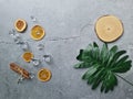 Grey background decorated with dried orange slices, cinnamon sticks, pine wood chip and artificial green leaf Royalty Free Stock Photo