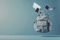 Grey backpack with travel accessories including laptop, tablet, and smartphone floating creatively Royalty Free Stock Photo