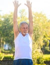 Grey Bearded Old Man in Vest Lifts Hands up Smiles in Park