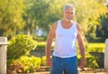 Grey Bearded Old Man in White Vest Stands Smiles in Park