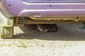 Grey beautiful cat sitting under an old car Royalty Free Stock Photo