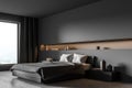 Grey bedroom corner with panoramic view, illuminated wall niche and bed