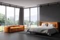 Grey bedroom interior with bed and couch near panoramic window Royalty Free Stock Photo