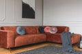 Grey, black, beige and pink round velvet pillows on ginger colored living room sofa