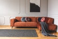 Grey, black, beige and pink round velvet pillows on ginger colored living room sofa