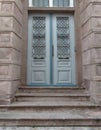 Grey blue and brown old style front door with metal frames. Stone wall and stairs. Royalty Free Stock Photo