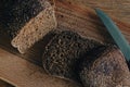 Grey bread with knife on wooden board. Wheat bread slices on cutting board. Bakery products. Crusty grain bread on table Royalty Free Stock Photo