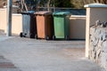 Grey, brown and green wheelie bins out in a street ready for collection. Waste management and industry concept