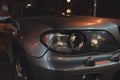 Grey car with broken headlight after a crash accident.