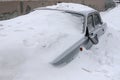 Grey car with a broken rearview mirror under a layer of snow Royalty Free Stock Photo