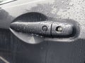 A grey car door handle, covered in rain drops after a storm in the pacific northwest Royalty Free Stock Photo