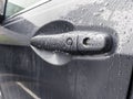 A grey car door handle, covered in rain drops after a storm in the pacific northwest Royalty Free Stock Photo