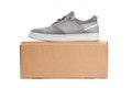 Grey casual sports shoes/sneaker on a brown cardboard box isolated on a white Royalty Free Stock Photo