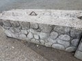 Grey cement barricade with stones and metal