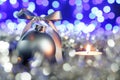 Grey christmas ball and candle, blured purple lights at the background Royalty Free Stock Photo