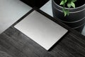 grey closed laptop on black wooden table, mockup