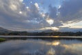 Grey clouds and yellow sunlight reflect on the water Royalty Free Stock Photo