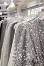 grey women\'s festive elegant clothes with sequins and rhinestones on hangers in the store. the concept of conscious