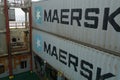 Grey container of Maersk company with white star logo stowed on the container vessel between cell guides.