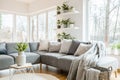 Grey corner couch with pillows and blankets in white living room